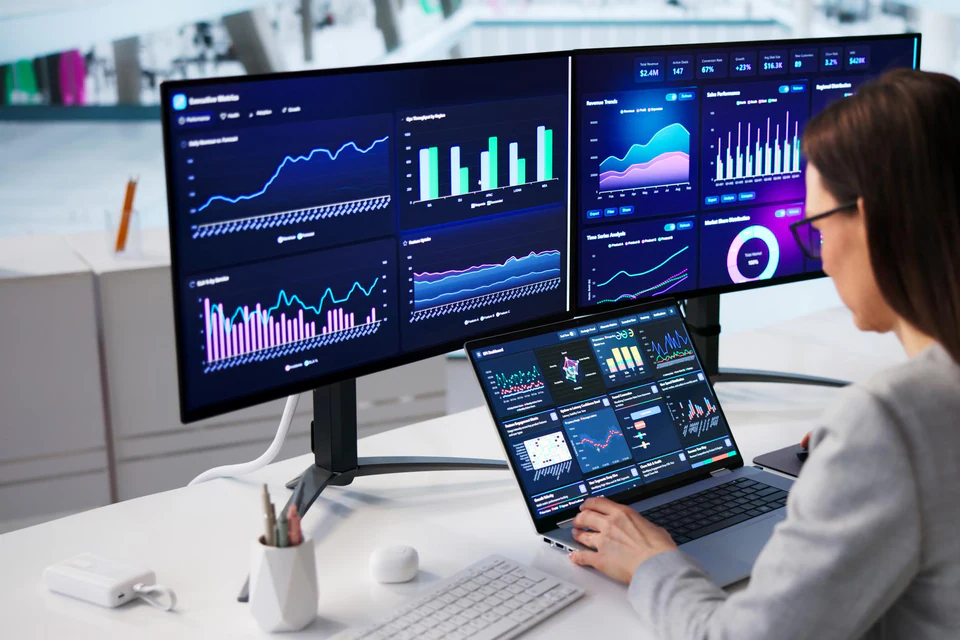 Banking analyst reviewing operational dashboards across multiple screens.