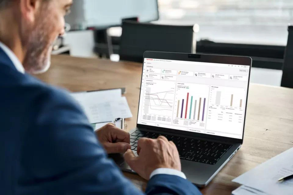 Finance professional reviewing reporting dashboards on a laptop.