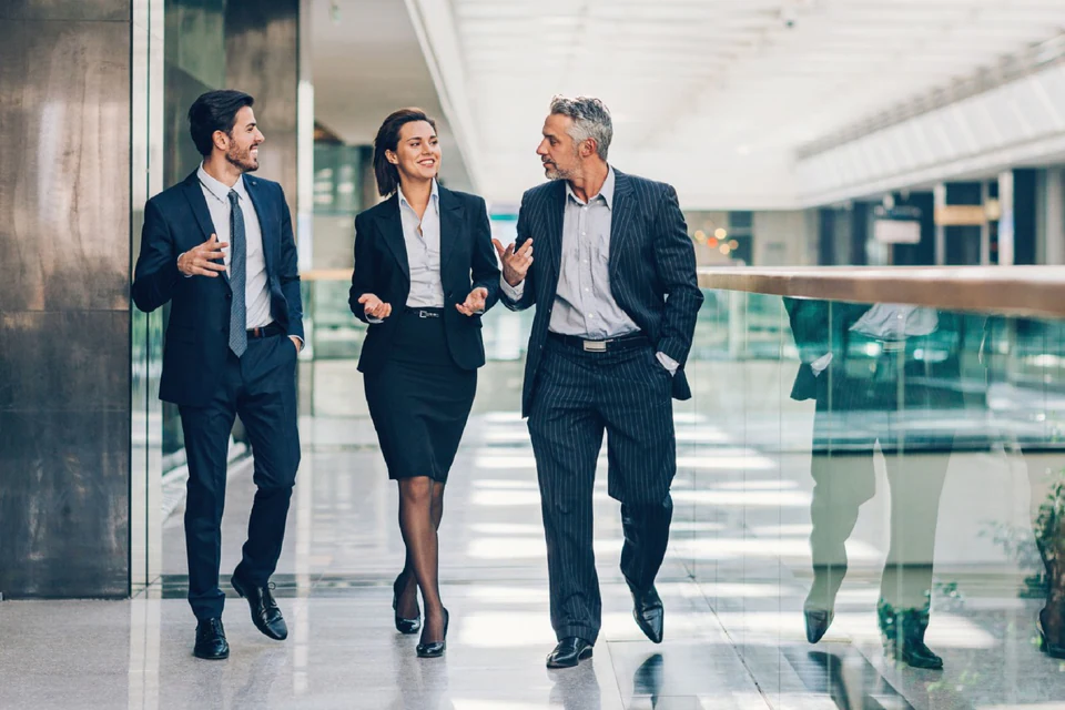 Banking colleagues walking together through a modern office.